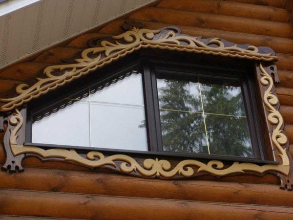 Деревянные наличники на окне в деревянном доме